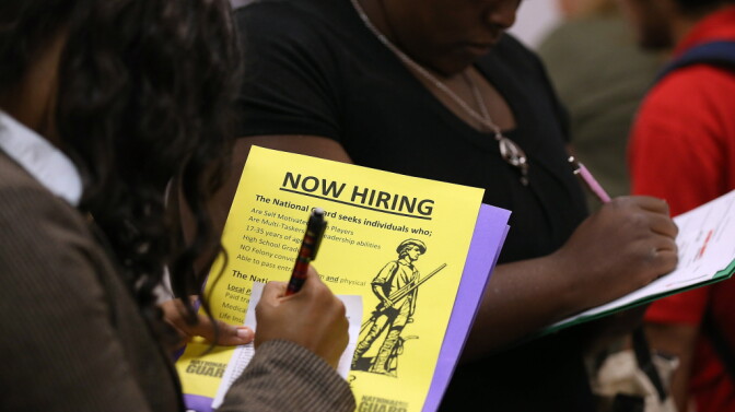 Attendees of a job fair in California in October fill out paperwork.