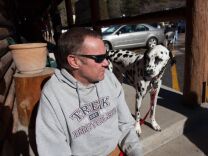 Rick Heltebrake relates the tale of how Christopher Dorner hijacked his truck on Highway 38 to reporters while his dog Suni hangs around.