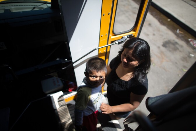 A mother picks up her child from the bus that takes children home around Oxnard from a day at Headstart.