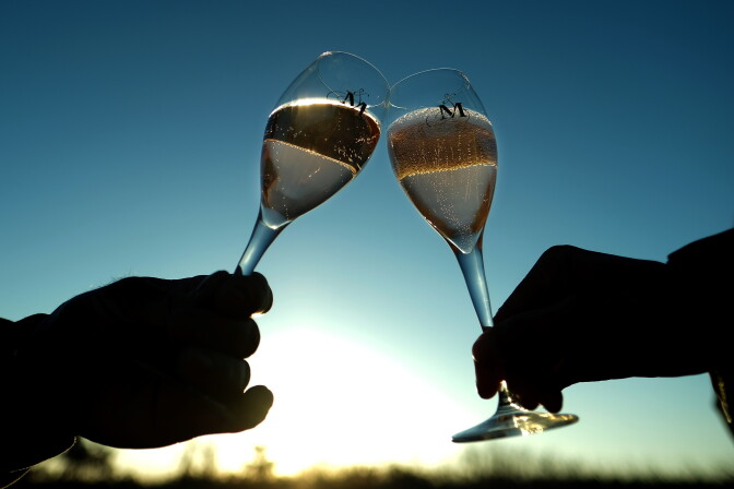 People hold glasses of rose wine on January 3, 2017 in Cabrieres d'Aigues, France.