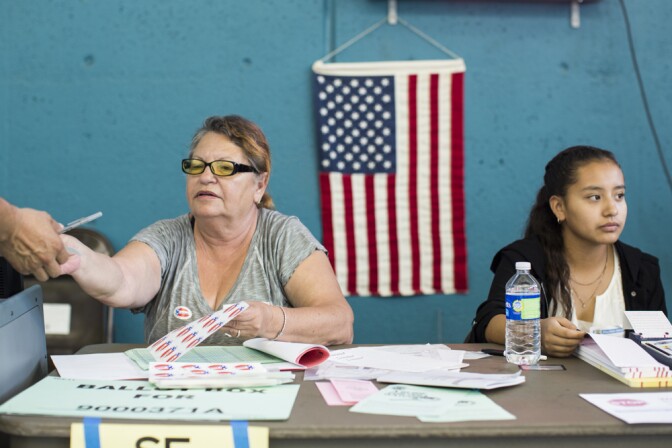 Poll Workers Apolonia Corrales, left, and Laura Pallares help voters cast their ballots at Echo Park Deep Pool in Los Angeles on Tuesday afternoon, Nov. 8, 2016. Pallares is a student at Edward R. Roybal Learning Center and this is her first time volunteering.