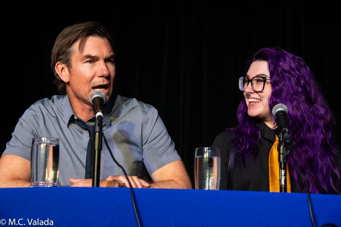 Jerry O'Connell, a white man and Mallory O'Meara, a woman with purple long hair, sitting at the judges table