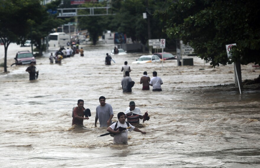 Residents attempt to flee from the flooded area in Acapulco, Guerrero state, Mexico, after heavy rains hit the area on Sept. 16, 2013.