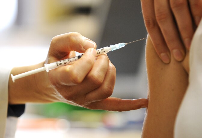 A woman receives a swine flu vaccine in the eastern German city of Dresden on November 4, 2009. Tiny infants are most likely to be hospitalized with swine flu, but people over the age of 50 are most at risk of dying in hospital from the disease, US researchers said. AFP PHOTO DDP /  NORBERT MILLAUER GERMANY OUT (Photo credit should read NORBERT MILLAUER/AFP/Getty Images)