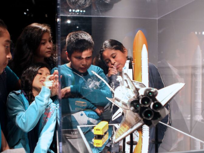 Children from Dr. Theodore T. Alexander Science Center School look at a model of the space shuttle during a preview of Endeavour: The California Story exhibit at the California Science Center.