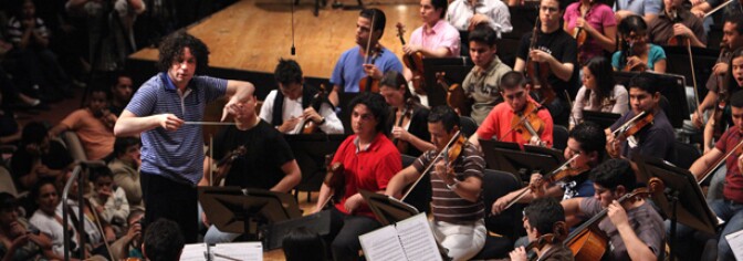   	Venezuelan conductor Gustavo Dudamel (L) conducts musicians of El Sistema, The Simon Bolivar National Youth Orchestra (the Venezuelan musical education program), during a rehearsal in Caracas on June 3,2009. Dudamel is actually the Los Angeles Philarmonic's music director as of the 2009-2010 season.