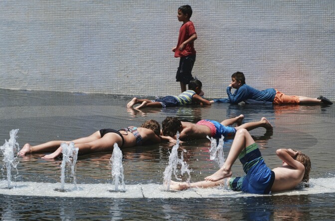 Children try to cool down and take advantage of the Grand Park fountain in downtown Los Angeles on Wednesday, July 5, 2017. Forecasters say a new heat wave is setting in across the interior of Southern California, and the southern Sierra Nevada is facing a period of elevated fire danger. The National Weather Service says the heat is coming from high pressure building over the desert Southwest that will expand westward. (AP Photo/Richard Vogel)