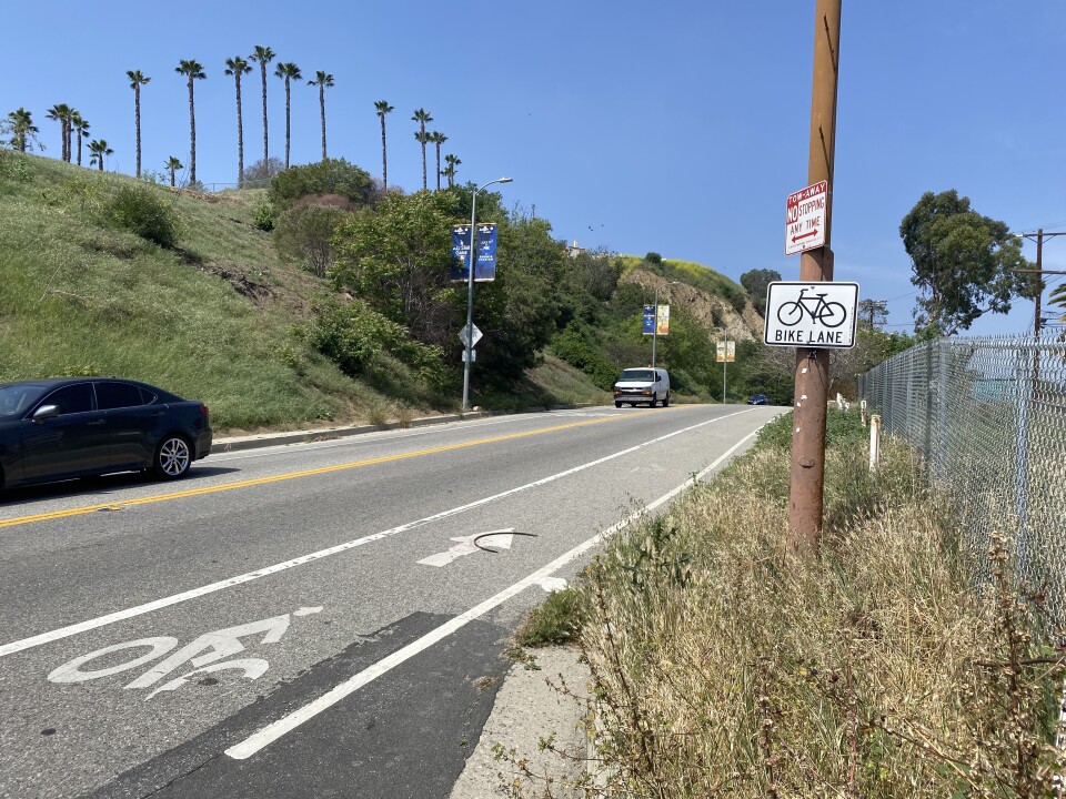 A bike lane with on a stenciled figure of a bicyclist on the side of a road.
