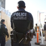 SAN YSIDRO, CA - APRIL 09:  A U.S. Customs and Border Protection officer stands guard as pedestrians enter the United States at the San Ysidro port of entry on April 9, 2018 in San Ysidro, California. President Trump has issued a decree for the National Guard to guard the 3,200 kilometer border between the United States and Mexico.  (Photo by Mario Tama/Getty Images)