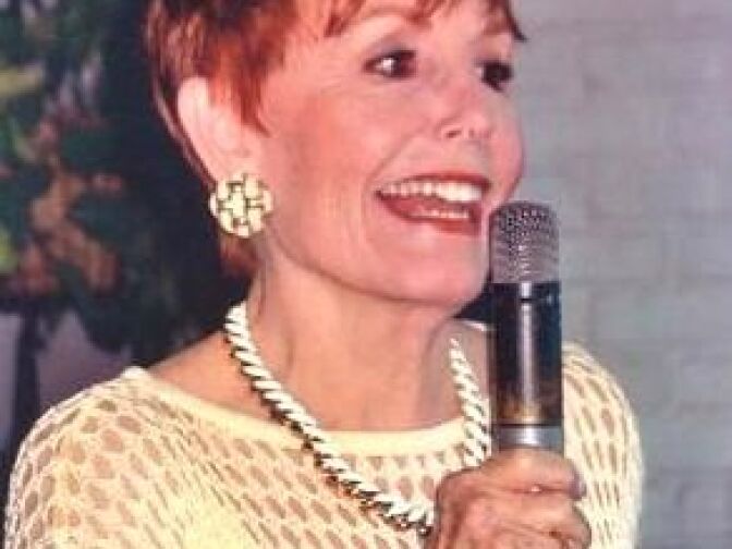 Betty Hoover introducing one of the acts at her home jazz salon, Jazz at the A Frame.