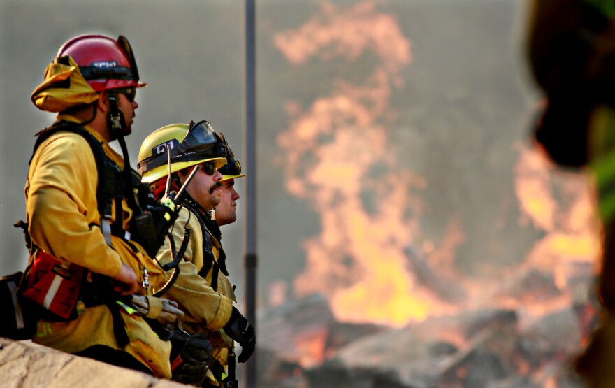 MALIBU, CA - NOVEMBER 11: Firefighters battle a blaze at the Salvation Army Camp on November 10, 2018 in Malibu, California. The Woolsey fire has burned over 70,000 acres and has reached the Pacific Coast at Malibu as it continues grow.  (Photo by Sandy Huffaker/Getty Images)