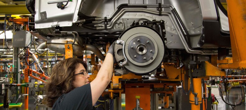 JoAnne Prince, a GM employee for 20 years, installs shocks and brake lines on a 2015 Chevrolet Traverse