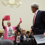 Members of CodePink, Tighe Barry (L) and Medea Benjamin (2nd L) protest as U.S. Secretary of State John Kerry (R) arrives at a hearing on "Syria: Weighing the Obama Administration's Response" before the House Foreign Affairs Committee September 4, 2013 on Capitol Hill in Washington, DC. 