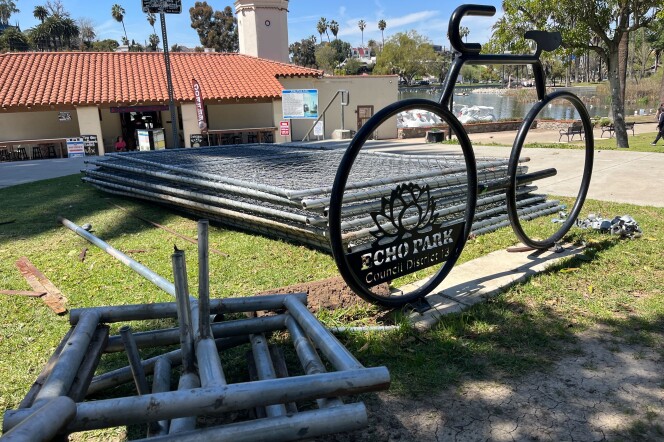 A pile of fences sit on a grassy patch at Echo Park Lake