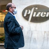 NEW YORK, NY - NOVEMBER 09: People walk by the Pfizer headquarters on November 9, 2020 in New York City. Pharmaceutical company Pfizer announced positive early results on its COVID-19 vaccine trial and has proven to be 90% effective in preventing infection of the virus. (Photo by David Dee Delgado/Getty Images)