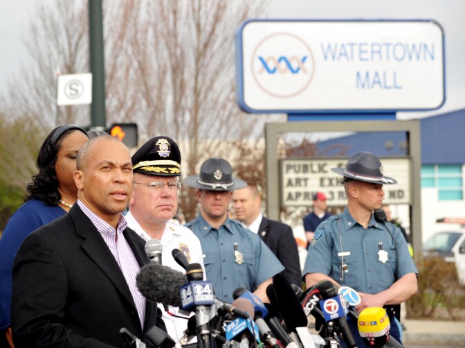 Massachusetts Governor Deval Patrick (L) speaks to the media at a shopping mall on the perimeter of a locked down area as a search for the second of two suspects wanted in the Boston Marathon bombings takes place on April 19, 2013 in Watertown, Massachusetts.