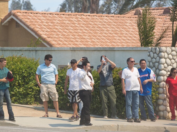 Onlookers watch as firefighters fight flames near Banyan Street and Los Osos High School as the Etiwanda Fire burns in Rancho Cucamonga on Wednesday, April 30, 2014.