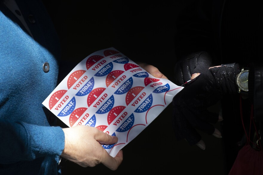 PHILADELPHIA, PA - OCTOBER 17:  A  volunteer gives an "I VOTED TODAY" sticker to a woman after she cast her early voting ballot at the A. B. Day School polling location on October 17, 2020 in Philadelphia, Pennsylvania.  With the election only a little more than two weeks away, a new form of in-person early voting by using mail ballots, has enabled millions of voters to cast their ballots.  President Donald Trump won the battleground state of Pennsylvania by only 44,000 votes in 2016, the first Republican to do so since President George Bush in 1988.  (Photo by Mark Makela/Getty Images)