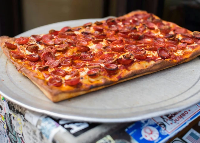 Uma grande fatia retangular de pizza de calabresa.