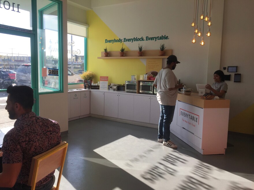 Everytable employee Jailene Miranda helps a customer check out at the South L.A. location of Everytable. Miranda grew up in South L.A. and is studying health sciences at California State University, Long Beach. She said she had to be part of Everytable after she walked in about a year ago and heard about its mission. “This is where I grew up and we need this,” she said.