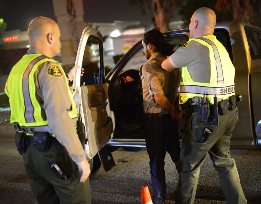 Los Angeles Sheriff's Department deputies stop a man at a DUI checkpoint Thursday night in Bellflower. He was later released after passing a breathalyzer test.