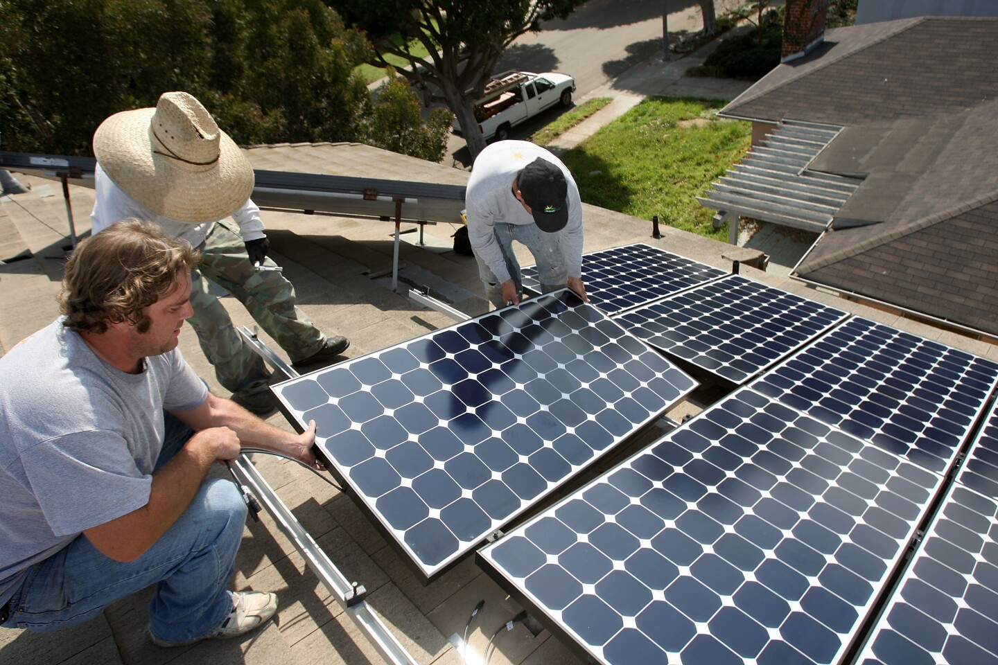 SANTA MONICA, CA - FEBRUARY 27:  Employees of Solar Forward install solar electric panels on a residential rooftop on February 27, 2009 in Santa Monica, California. President Obama signed into law an economic-recovery package containing more than $20 billion investing in a greener economy, including $500 million for green job training.  According to the Council of Economic Advisers, 'green' jobs pay 10 to 20 percent more than other jobs and are more likely to be union jobs. Consumers also benefit from lower electric and heating bills through solar electric, solar water heating, and building weatherization upgrades.   (Photo by David McNew/Getty Images)