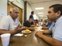 Rigoberto Bejarano (left) talks with intake coordinator Salvador Mendoza at Proyecto Pastoral. The group established The Guadalupe Homeless Project in 1988 to address what it saw as a neglected issue in the community: emergency shelter for the homeless. 