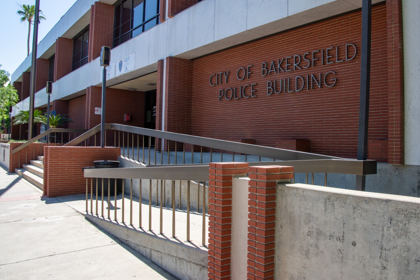 The red brick and concrete front of the Police department reads: City of Bakersfield Police Building