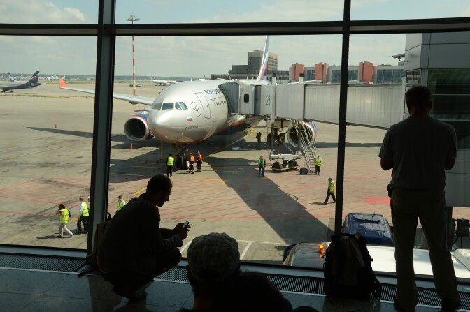 People look the passenger plane, flight SU 150 to Havana, docking to a boarding bridge at the Moscow Sheremetyevo airport on June 24, 2013. US intelligence leaker Edward Snowden was set to fly out of Russia today by flight SU 150 to Havana to seek asylum in Ecuador, as Washington demanded Moscow hand over the fugitive to face espionage charges at home.