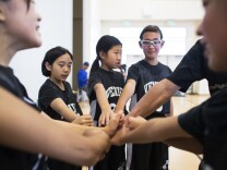 Fifth grade players Emi Takara, left, Claudia Fan and Maiya Kuida-Osumi and the Venice Sparks take a timeout during the West Los Angeles Youth Club's Invitational Basketball Tournament at Rancho Dominguez Preparatory School in Long Beach on Saturday morning, April 16, 2016. Southern California is home to decades-old Japanese American basketball leagues, in which more than 10,000 players of all ages participate.