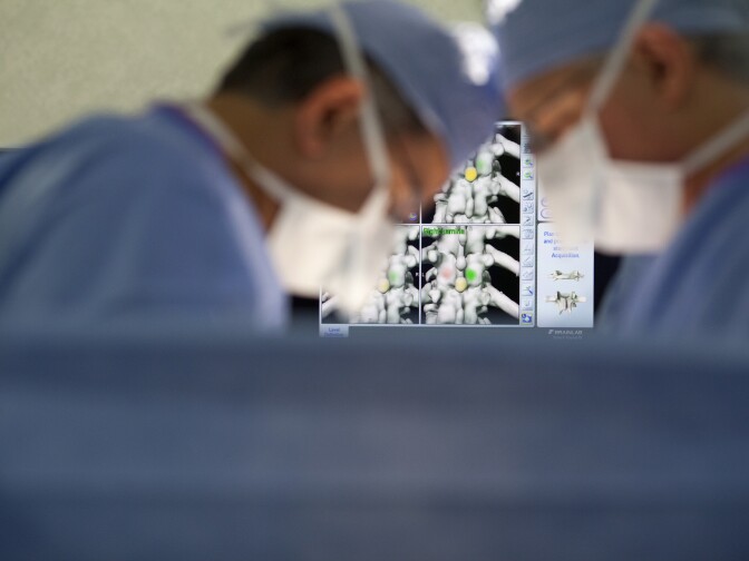 Dr. Jose Rodriguez, left, and Dr. Scott Lederhaus perform spine surgery at Foothills Presbyterian Hospital in Glendora. The surgeons are not part of a physician-owned distributorship, but contend that PODs create opportunity for surgeons to perform unnecessary procedures with financial benefits.