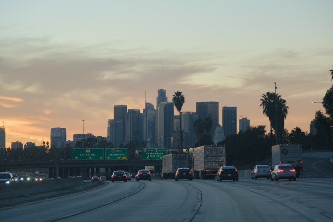 High rises of L.A.'s downtown skyline are seen against a sky at dusk.