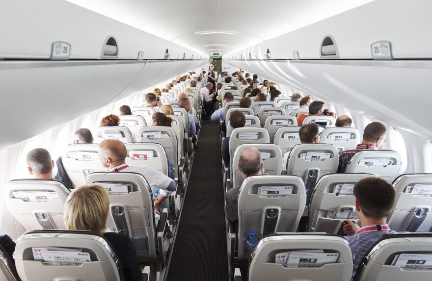 Passengers sit on July 6, 2016 aboard the Swiss International Air Lines' new Bombardier CS 100 passenger jetliner during a flight over the Swiss Alps.