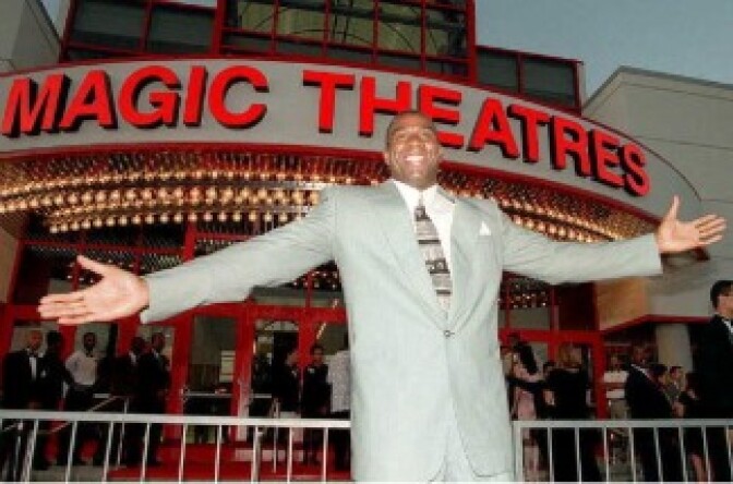 Former Los Angeles Lakers player Earvin 'Magic' Johnson stands in front of the 12-screen movie theatre that he built and financed during the theatre's grand opening. 