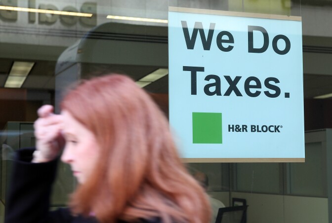 A pedestrian walks by an H & R Block office on April 15, 2011 in San Francisco, California. Despite having an extra three days to file your income taxes this year, an estimated 15 to 20 million people will wait to the very last minute to file their taxes with a high number relying on tax preparation services.  