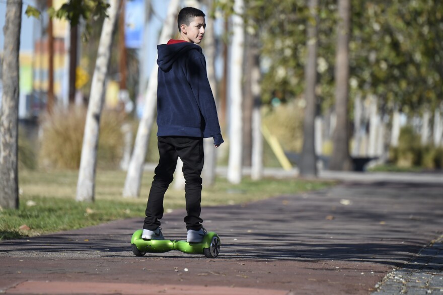 A boy rides a hoverboard on the day after Christmas, in San Pedro, Calif.. On Jan. 1, it became legal to cruise state streets via hoverboard.