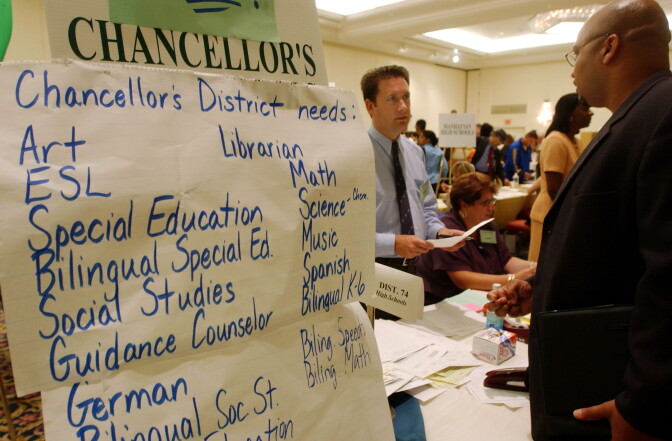  A teaching candidate speaks with a recruiter at a teachers job fair.