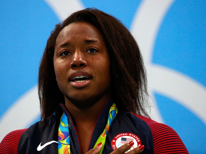 RIO DE JANEIRO, BRAZIL - AUGUST 11:  Gold medalist Simone Manuel of the United States celebrates on the podium during the medal ceremony for the Women's 100m Freestyle Final on Day 6 of the Rio 2016 Olympic Games at the Olympic Aquatics Stadium on August 11, 2016 in Rio de Janeiro, Brazil.  (Photo by Adam Pretty/Getty Images)