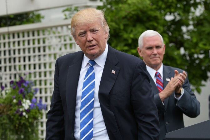 US Vice President Mike Pence (R) applauds US President Donald Trump during an event for the Independent Community Bankers Association in the Kennedy Garden of the the White House on May 1, 2017 in Washington, DC. / AFP PHOTO / MANDEL NGAN        (Photo credit should read MANDEL NGAN/AFP/Getty Images)