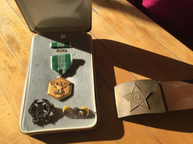 The Army Commendation Medal and silver Jump Wings awarded to Michael Gerwig during his time in the U.S. Army. At right is a Soviet Army belt given to Gerwig in St. Petersburg, Russia, by Russian veterans of the Soviet war in Afghanistan.