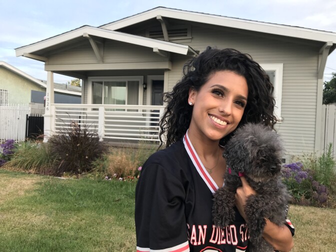 Jackie Dillon stands in front of the South Los Angeles home she purchased earlier this year, July 18, 2018. (David Wagner/KPCC)