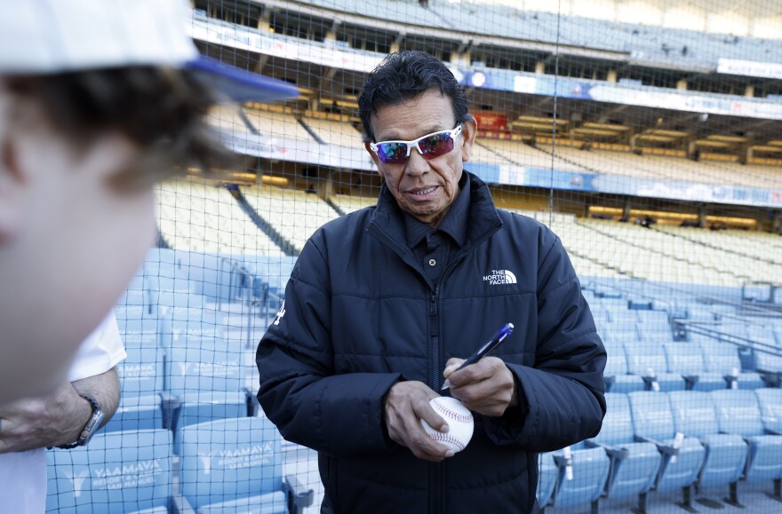 Former pitcher Fernando Valenzuela of the Los Angeles Dodgers gives autographs to fans before the game against the San Francisco Giants at Dodger Stadium on April 1, 2024 in Los Angeles, California.