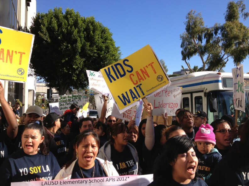 Parents of children at 24th Street Elementary held up placards for passing motorists as they descended upon LAUSD headquarters Thursday, Jan. 17, 2013 to deliver a petition to take over the failing school.