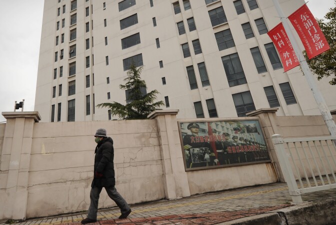 A person walks past a 12-story building alleged in a report on February 19, 2013 by the Internet security firm Mandiant as the home of a Chinese military-led hacking group after the firm reportedly traced a host of cyberattacks to the building in Shanghai's northern suburb of Gaoqiao. Mandiant said its hundreds of investigations showed that groups hacking into US newspapers, government agencies, and companies 'are based primarily in China and that the Chinese government is aware of them.'