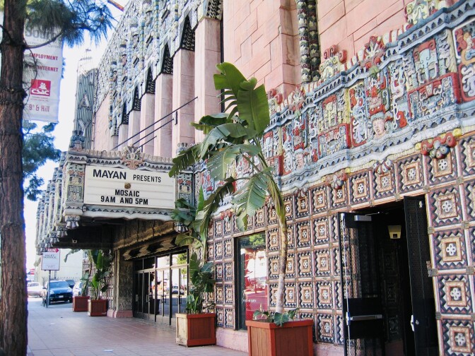 A theater entrance with potted trees.