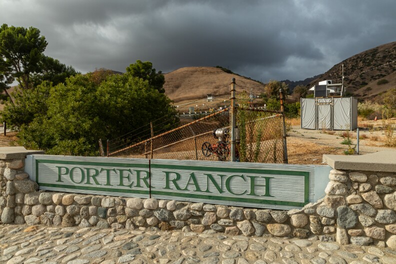 A sign reads "Porter Ranch." Beyond it is industrial equipment and brown hills under gray skies.