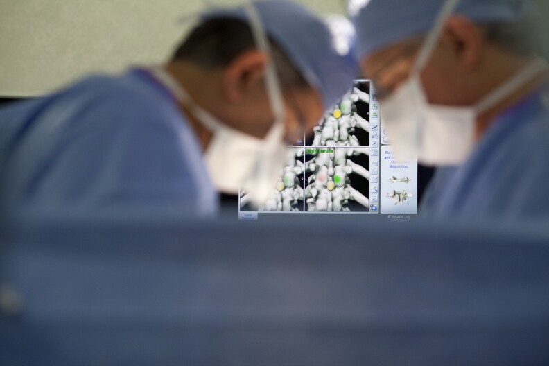 Dr. Jose Rodriguez, left, and Dr. Scott Lederhaus perform spine surgery at Foothills Presbyterian Hospital in Glendora. The surgeons are not part of a physician-owned distributorship, but contend that PODs create opportunity for surgeons to perform unnecessary procedures with financial benefits.