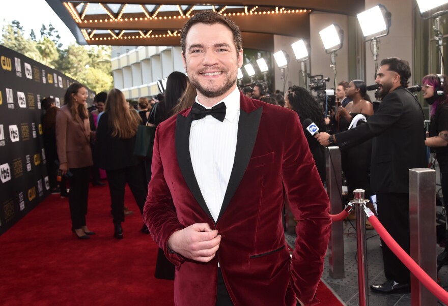 Daniel Durant wears a red crushed velvet dinner jacket on the red carpet.