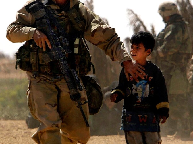 Soldiers with Alpha Company 1-30 Infantry Fort Benning Ga. attached to Task Force 3-7  Infantry, 1st Brigade Combat Team 3rd Infantry Division from Fort Stewart Ga., helps a young Iraqi boy find his father who was being searched by other troops outside of their homes near the town of Al Najaf in Iraq Thursday March 27, 2003. U.S. Army troops came under both direct and inderect fire all day long prompting the search of the area just outside the town.   