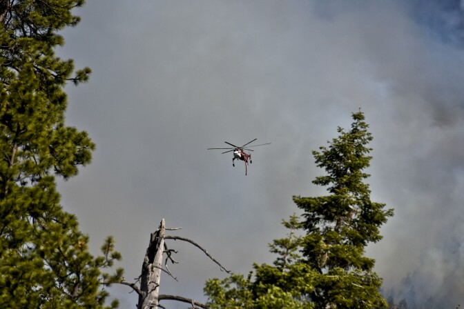 A helicopter flies over the Lake Fire Thursday afternoon off Jenks Lake Road in the San Bernardino National Forest. 